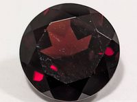 Top view of round faceted garnet showing color and cut