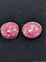 Two oval pink star rubies on black background