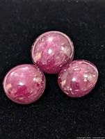 Three star ruby cabochons on black background
