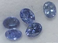 Five oval faceted tanzanite gemstones close-up