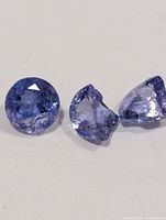 three tanzanite gemstones on white background