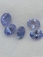 Five loose oval tanzanite gemstones close-up