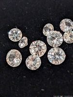 Loose round white sapphire gemstones on black background