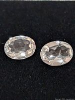 pair of oval transparent gemstones on black surface