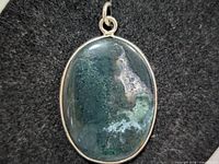 front view of oval green moss agate pendant in silver bezel