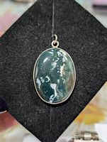 Front view of oval moss agate pendant in silver bezel