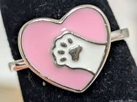 Front view of sterling silver ring showing pink enamel heart with paw print design