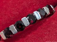 Close-up of garnets and bar settings on ring