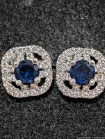 Front view of both earrings showing blue center stones and CZ halos