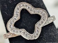 Front view of silver ring showing open quatrefoil bezel with pavé CZ stones
