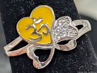 Front view showing yellow enamel Om heart and CZ heart