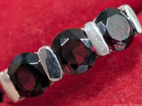 Close-up of three garnet stones with silver spacers