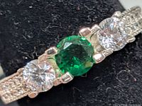 Front view showing green centre stone and clear side stones
