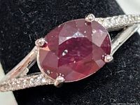 Close-up of front showing oval dyed ruby and prong setting