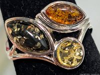 Front view showing green, cognac and yellow amber stones in silver setting