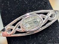 Front view of silver ring with oval labradorite stone and openwork shoulders