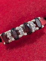Ring front showing five oval garnets and clear accent stones