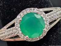 Front view of silver ring showing green onyx center stone and CZ halo