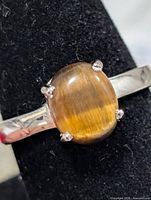 Front view of silver ring showing tiger eye cabochon and prong setting