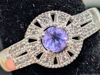 Front view of silver ring showing amethyst center and CZ halo