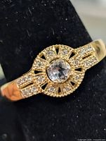 Front view of ring showing white topaz center and CZ halo