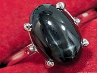 Front view of ring showing black onyx cabochon and prong/star setting