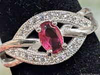 Front view showing ruby centre, cubic zirconia halo, twist design