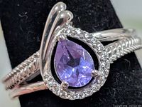Front view of silver ring with amethyst centre and CZ halo