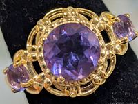 Close-up of ring face showing centre amethyst and ornate setting