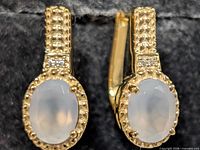 Front view of both earrings showing moonstones, bezel texture and accent stones