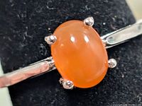 Front view of silver ring showing oval carnelian cabochon in four prongs