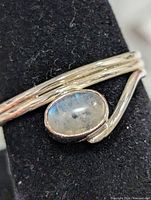 front view of silver triple-wire ring with oval moonstone