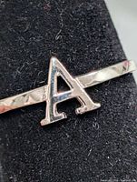 Front view of silver ring showing the letter A