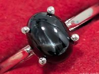 Front view of black onyx ring showing stone and prongs