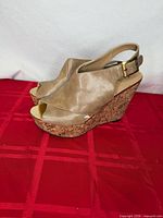 Full side view of both tan leather cork wedge heels