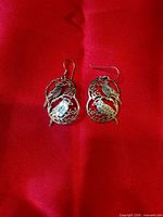 Front view of both earrings on red fabric