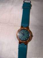Front view of wristwatch showcasing dial, wood case and strap