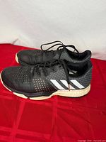 Side view of both shoes showing upper, stripes, Boost midsole