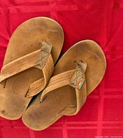 Top view of both flip-flops showing straps, footbeds, leather wear marks