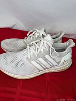 Side view of both sneakers showing uppers, midsole and heel