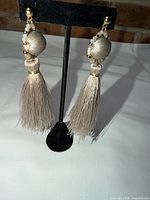 Pair of tassel earrings on stand showing full length and colour