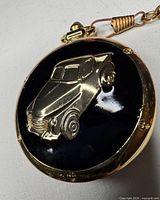 Front view of pocket watch showing truck motif and goldtone finish