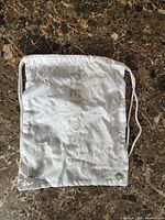 Front view of white Nike drawstring bag laid flat