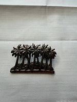 front view of silver-tone palm tree brooch pin