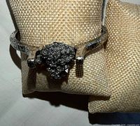 Top view of silver-tone cuff bracelet showing gray nugget cluster and textured band