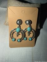 Front view of both earrings on card showing overall design and stones
