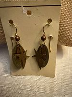 front view of earrings on card showing star overlays and mixed metal layers