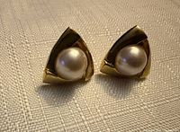 Front view showing triangular gold tone design and faux pearl centers