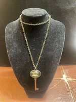 Full view of necklace on display bust showing chain length and pendant