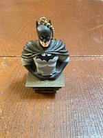 Front view of Batman bust keychain showing suit and pedestal logo